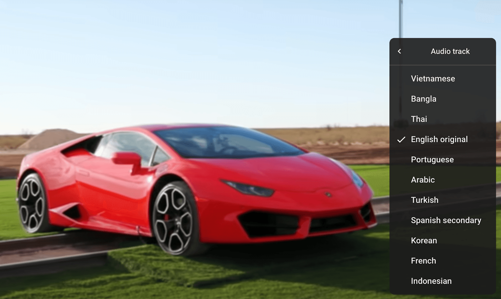 Red sports car on a grassy field with a menu overlay showing language options.